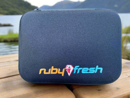 Black goggle case with 'ruby fresh' logo on a wooden surface by a lake